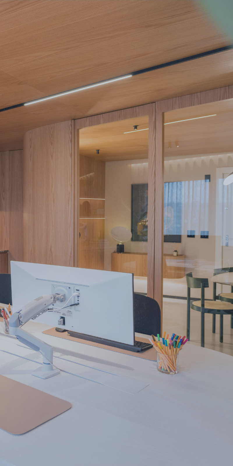 Modern executive office with warm wood finishes, collaborative workspace, and private meeting area representing strategic business planning and long-term decision-making.