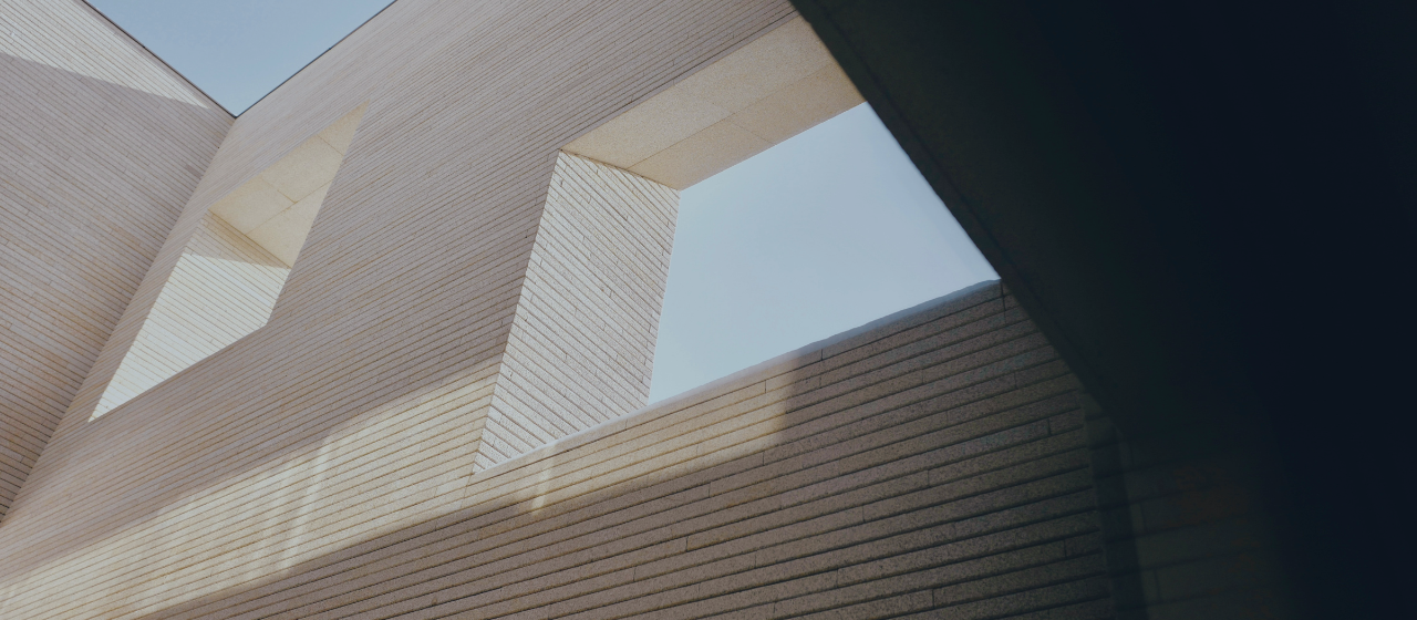 Modern architectural stone structure with geometric lines and natural light, representing long-term stability and sophisticated planning.