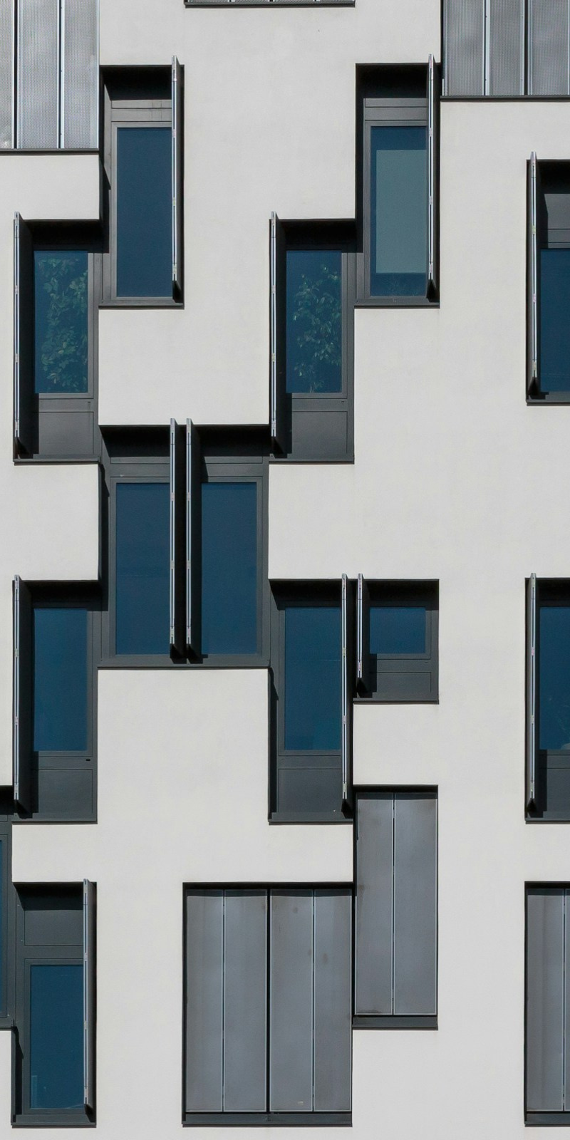Modern building facade with repeating window patterns and geometric structure representing organization, coordination, and integrated planning.