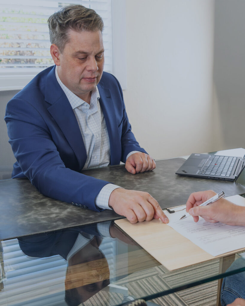 Jeff Cardon reviewing estate planning documents with a client in his Pleasant Grove, Utah office.