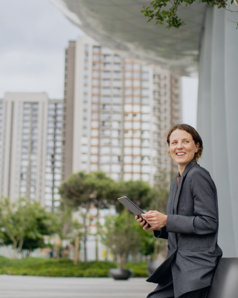 Woman holding a tablet outside a multifamily residential development.